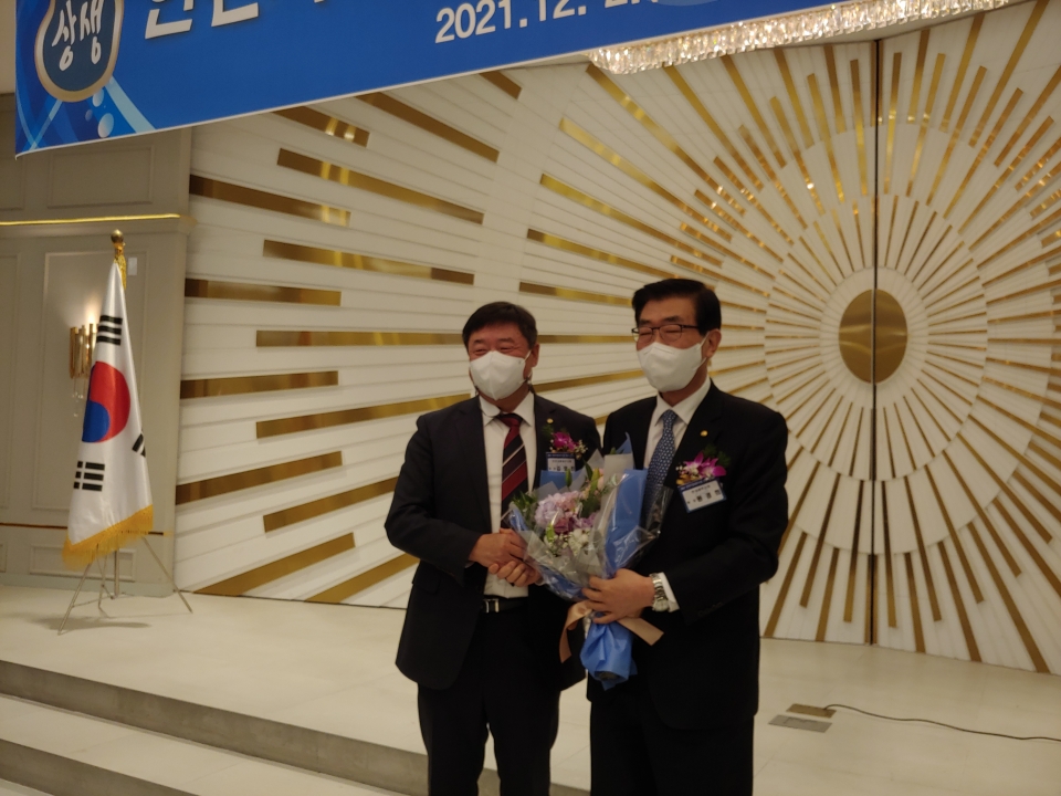 김명진 인천세무사회장(왼쪽)이 세무사법 개정을 성공적으로 이끈 원경희 한국세무사회장에게 꽃다발을 전달하고 있다.
